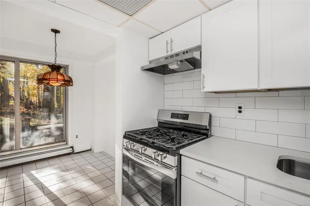 a kitchen with stainless steel appliances granite countertop a stove a refrigerator and a white cabinets