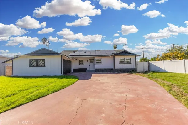 a front view of a house with a garden and yard