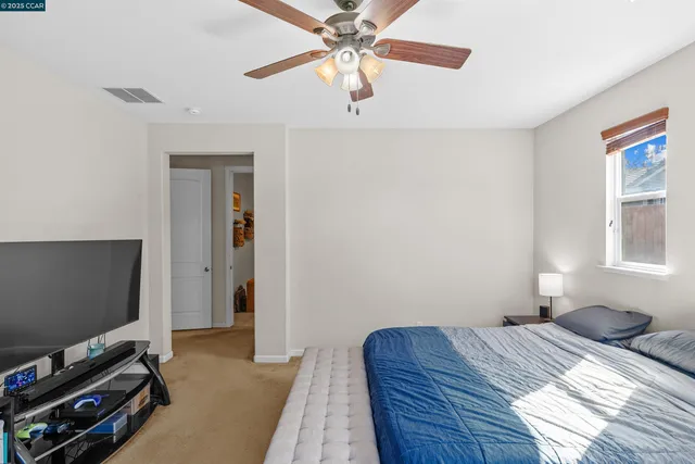 a bedroom with a bed and a flat tv screen on a dresser