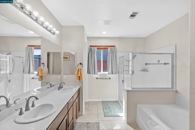 a bathroom with a granite countertop sink a toilet a mirror and shower