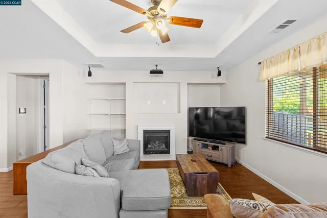 a living room with furniture a flat screen tv and a fireplace