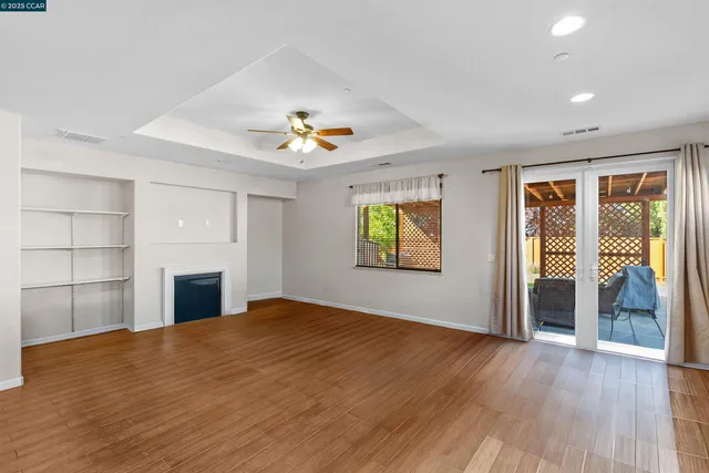 an empty room with a fireplace and wooden floor