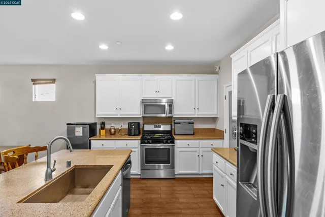 a kitchen with stainless steel appliances granite countertop a refrigerator sink and stove