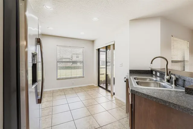 a kitchen with stainless steel appliances granite countertop a sink and a refrigerator