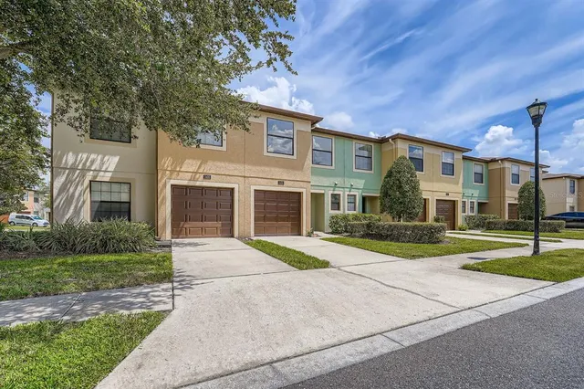 a front view of a house with a yard and trees