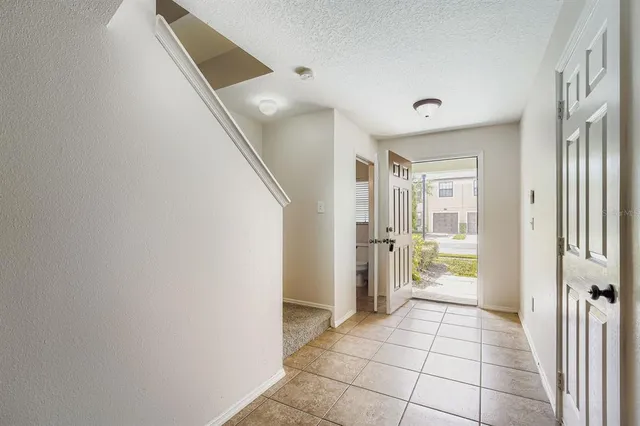 a view of a hallway to a livingroom with wooden floor and a kitchen space