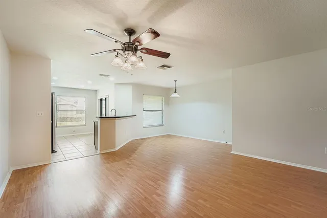 a view of a kitchen with wooden floor and a ceiling fan