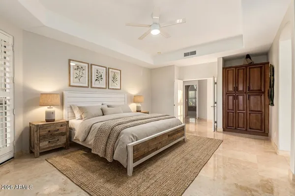 a spacious bedroom with a bed and a refrigerator