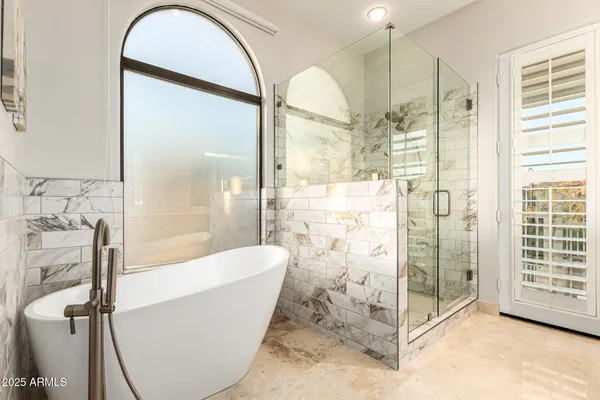 a bathroom with a bathtub and a glass door shower