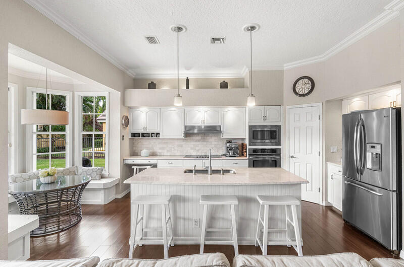 2620 Windham Court Delray Beach, FL 33445 - Photo 11 of 58 a kitchen with a table chairs refrigerator and cabinets
