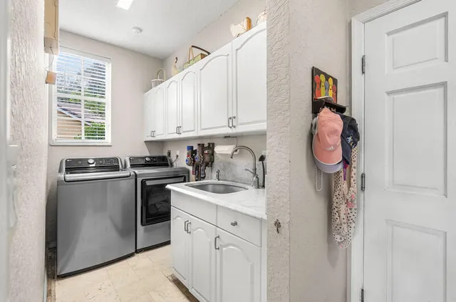 a view of swimming pool with lawn chairs and plants
