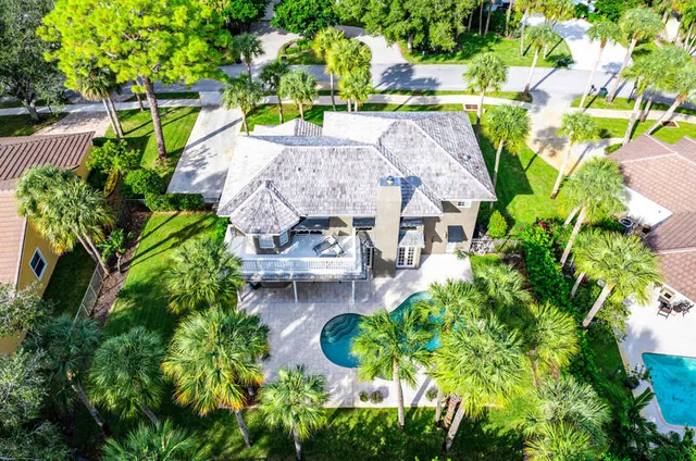 an aerial view of residential houses with outdoor space and trees all around