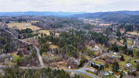 an aerial view of mountain with residential house and green space