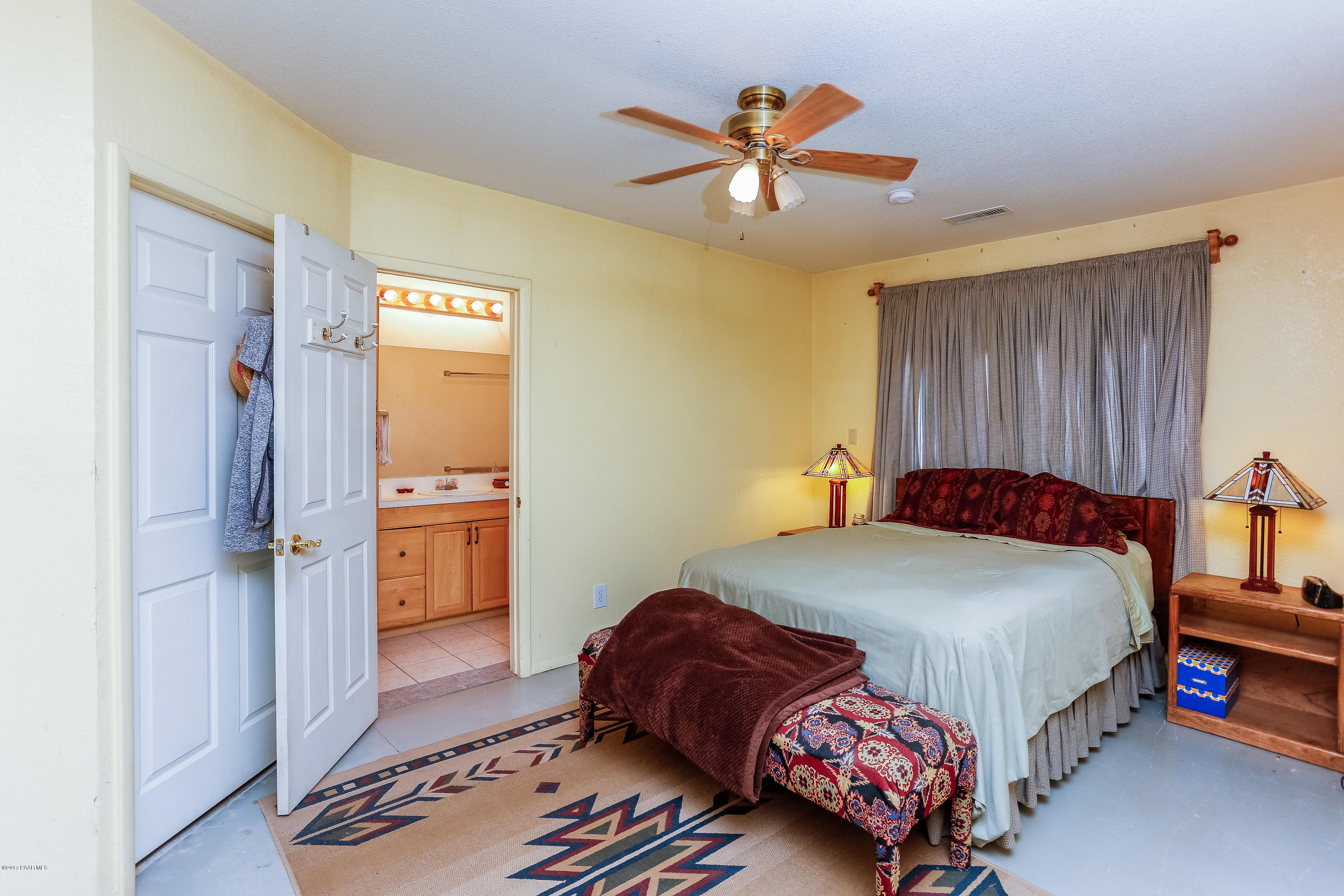1900 West Big Sky Ranch Road Paulden, AZ 86334 - Photo 14 of 39 a bedroom with a bed and a chandelier