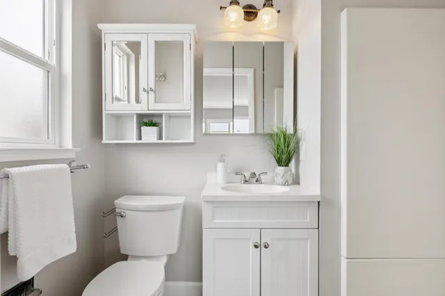 a bed sitting in a bedroom next to a window with potted plant