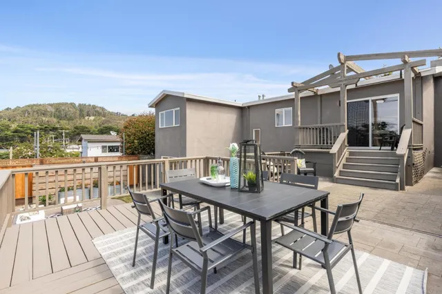 a living room with patio furniture and a garden