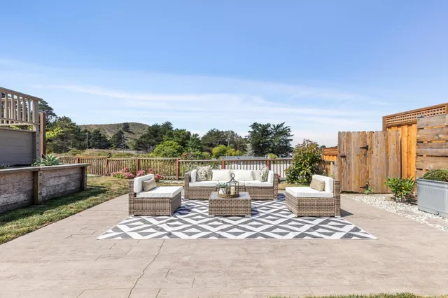 a patio with couches and a potted plant on the table