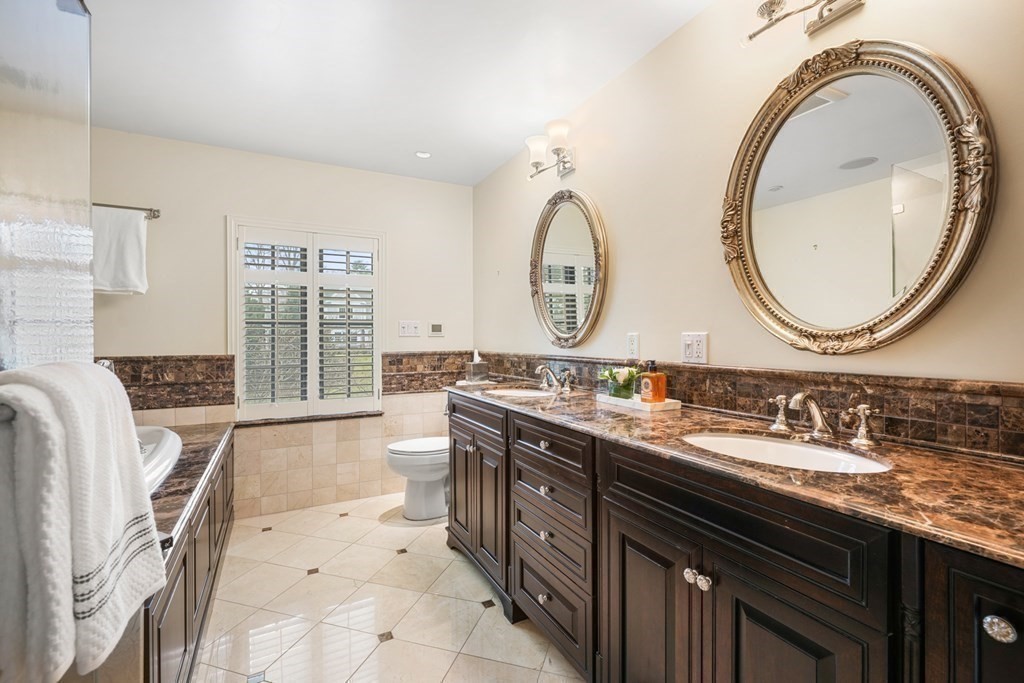 77 Woodcliff Road Wellesley, MA 02481 - Photo 27 of 42 a bathroom with a granite countertop sink a mirror and a window