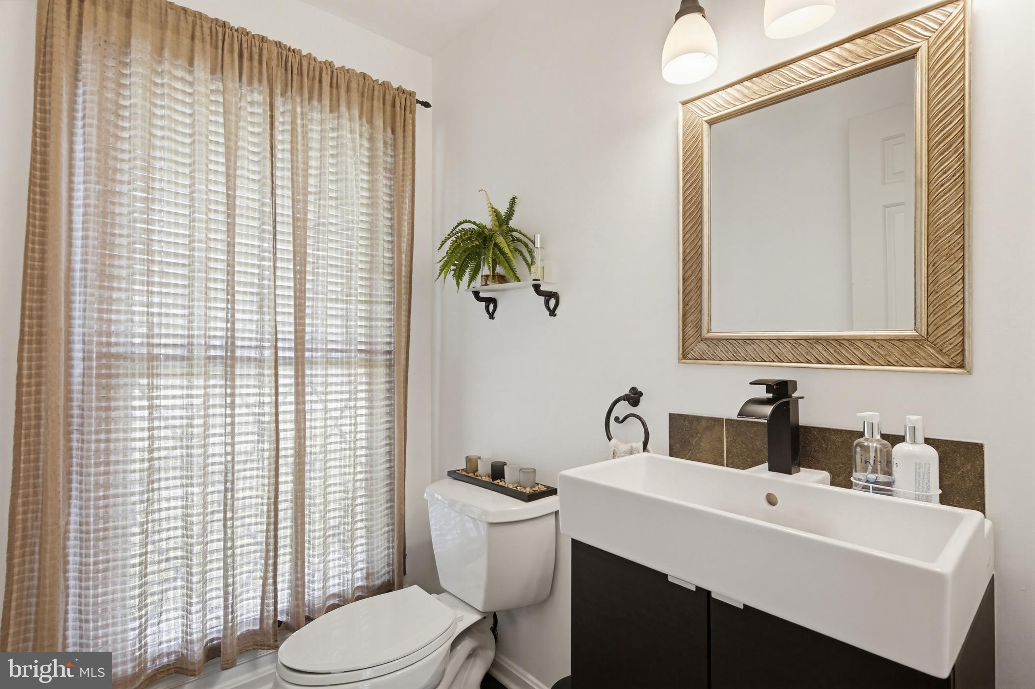 18906 Lindenhouse Road Gaithersburg, MD 20879 - Photo 9 of 48 a bathroom with a sink a toilet and mirror