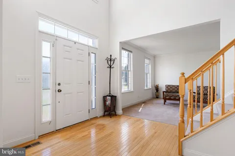 a view of a livingroom with wooden floor and stairs