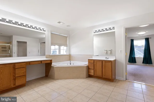 a spacious bathroom with a tub sink and mirror