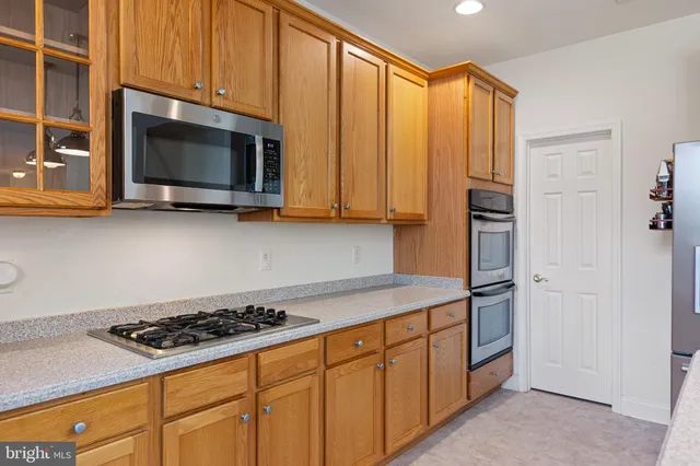 a kitchen with stainless steel appliances a stove a microwave cabinets and a counter top space