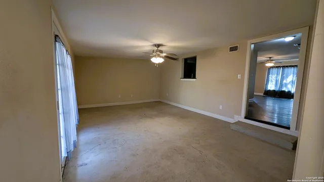 an empty room with a empty space and chandelier fan