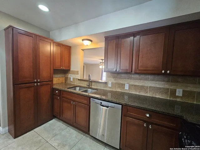 a kitchen with stainless steel appliances granite countertop wooden cabinets a sink and dishwasher