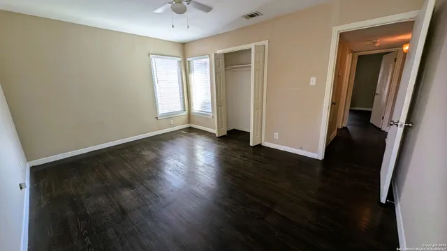 an empty room with wooden floor and a window