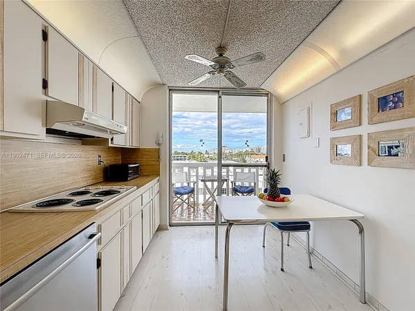 a kitchen with stainless steel appliances a stove a refrigerator a dining table and chairs with wooden floor