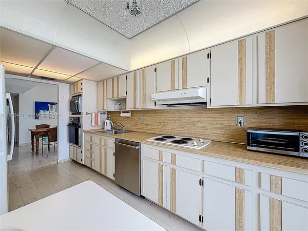 a kitchen with white cabinets and appliances