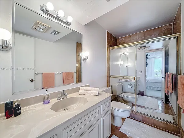 a bathroom with a sink a toilet a mirror and shower