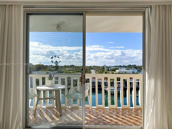 a view of a balcony with furniture and floor to ceiling window