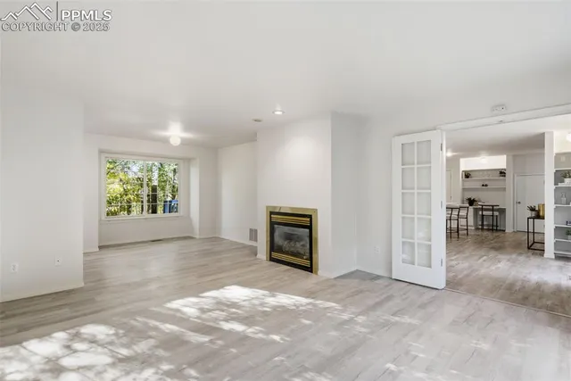 an empty room with windows and a fireplace