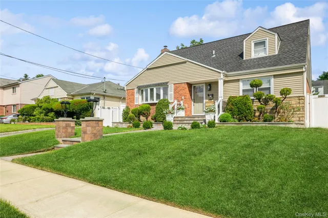 a front view of a house with a yard and potted plants