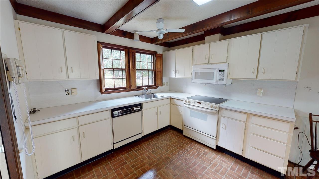 1114 Manchester Drive Raleigh, NC 27609 - Photo 15 of 30 a kitchen with granite countertop white cabinets and white appliances