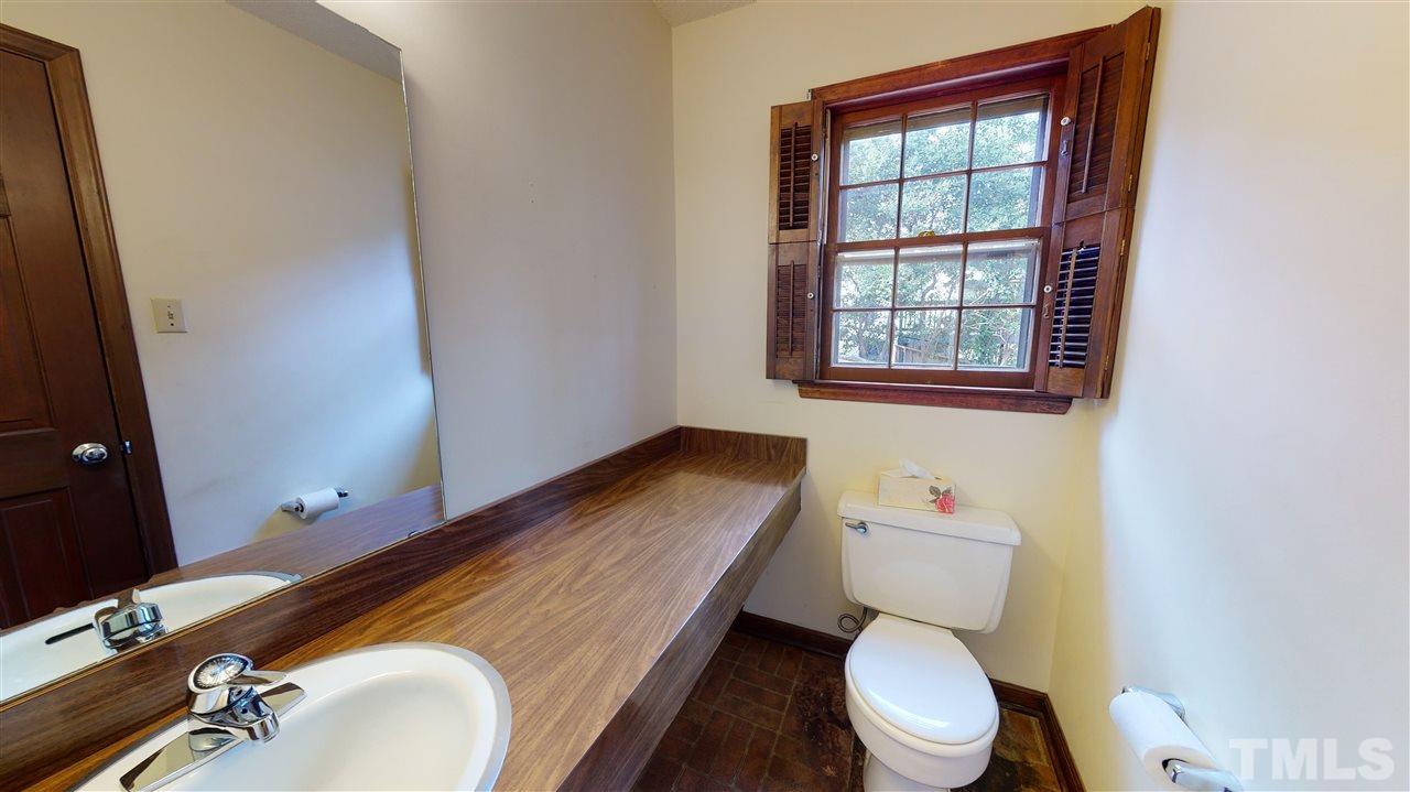 1114 Manchester Drive Raleigh, NC 27609 - Photo 24 of 30 a bathroom with a sink a toilet and a mirror