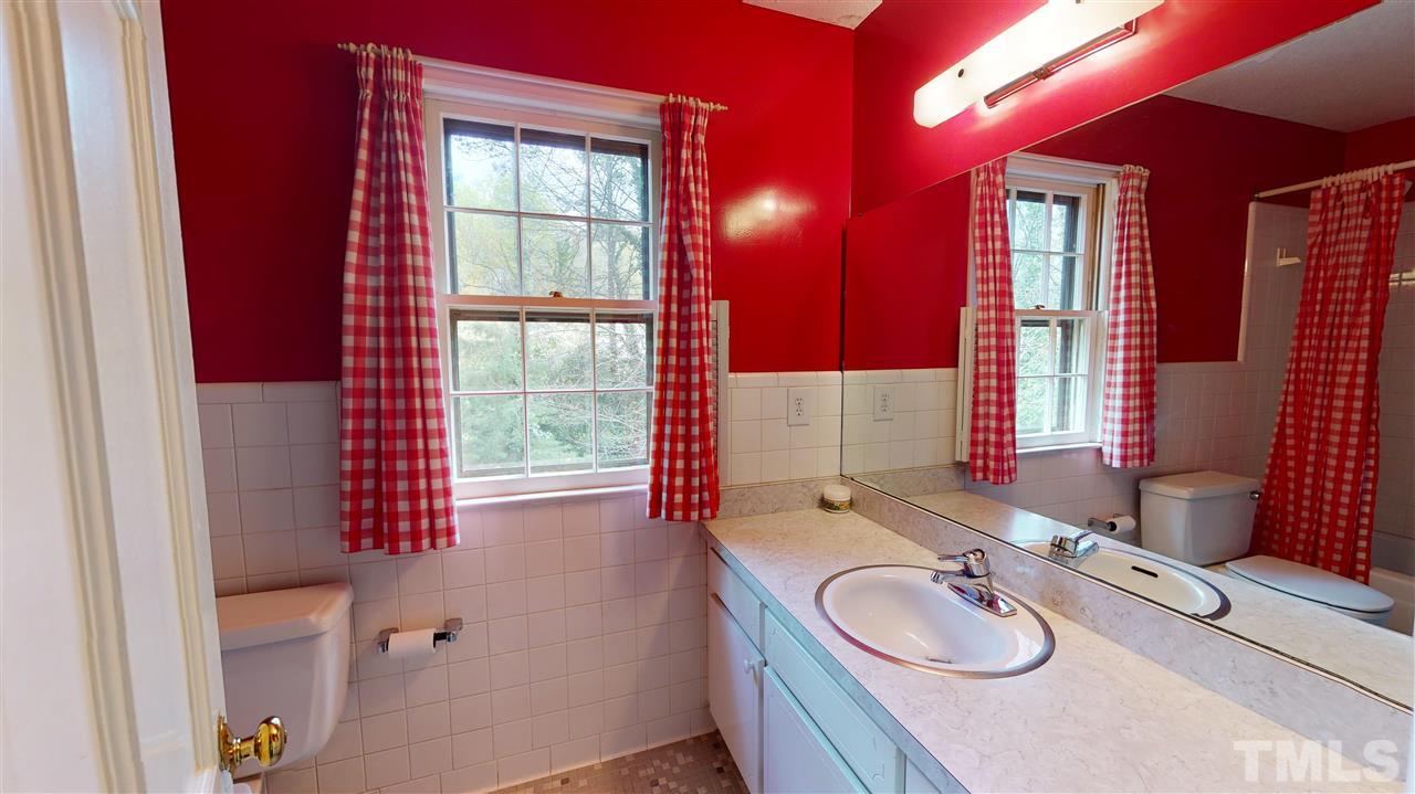 1114 Manchester Drive Raleigh, NC 27609 - Photo 26 of 30 a bathroom with a granite countertop sink and a mirror