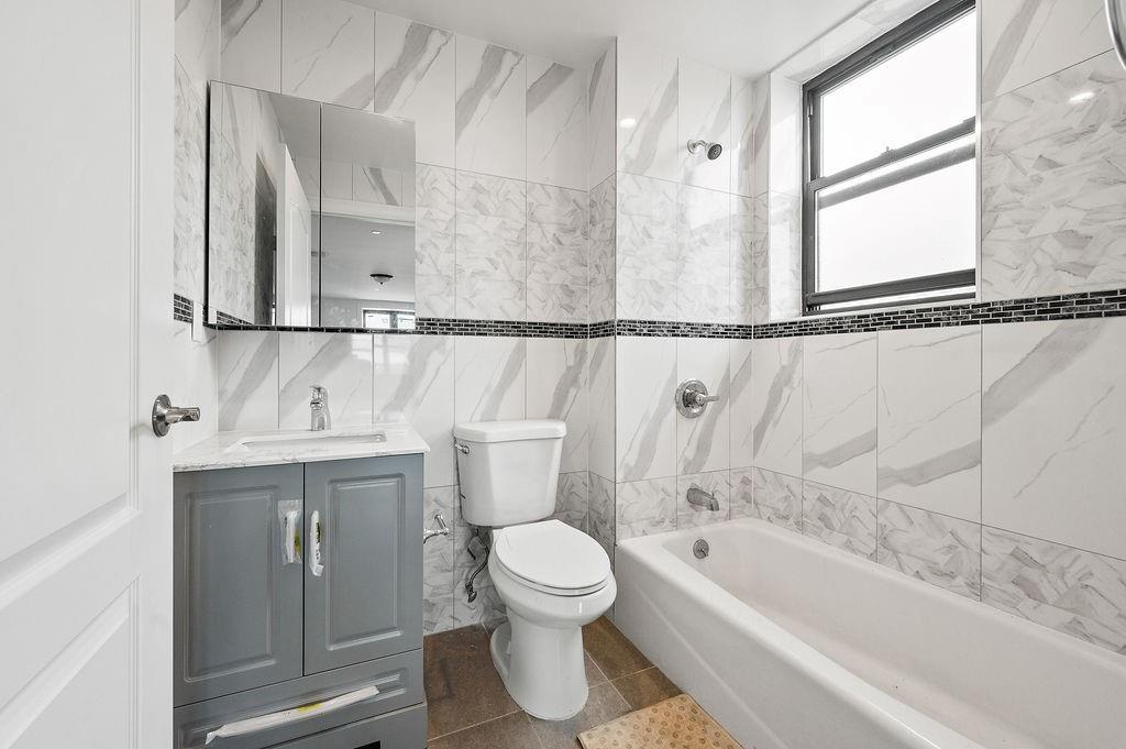 1307 84th Street, Unit 3B Brooklyn, NY 11228 - Photo 11 of 17 a bathroom with a toilet sink and bathtub