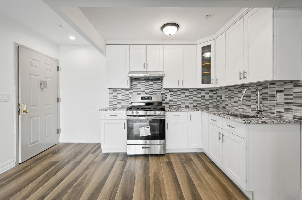 1307 84th Street, Unit 3B Brooklyn, NY 11228 - Photo 7 of 17 a kitchen with granite countertop white cabinets and white appliances