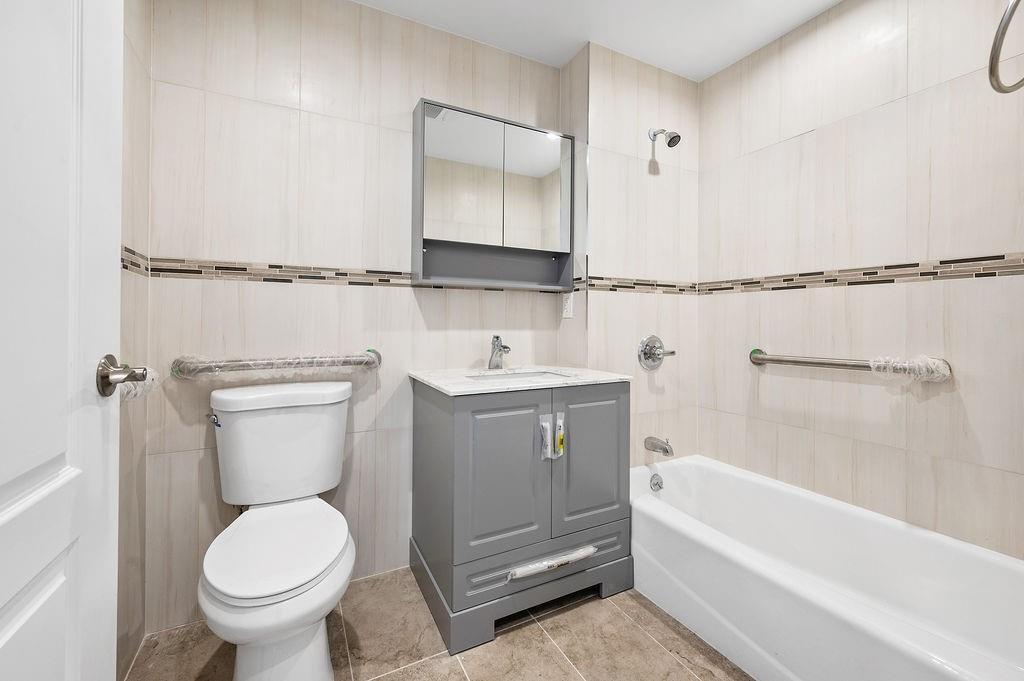 1307 84th Street, Unit 3B Brooklyn, NY 11228 - Photo 9 of 17 a bathroom with a sink a toilet and a bathtub
