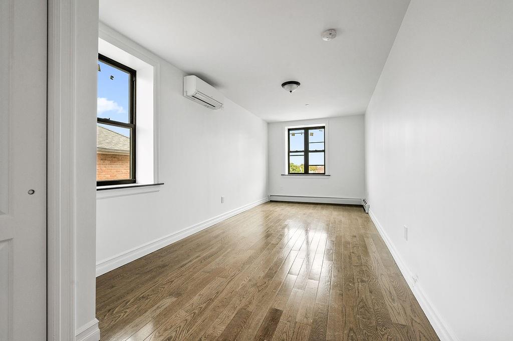 1307 84th Street, Unit 3B Brooklyn, NY 11228 - Photo 10 of 17 an empty room with wooden floor and windows