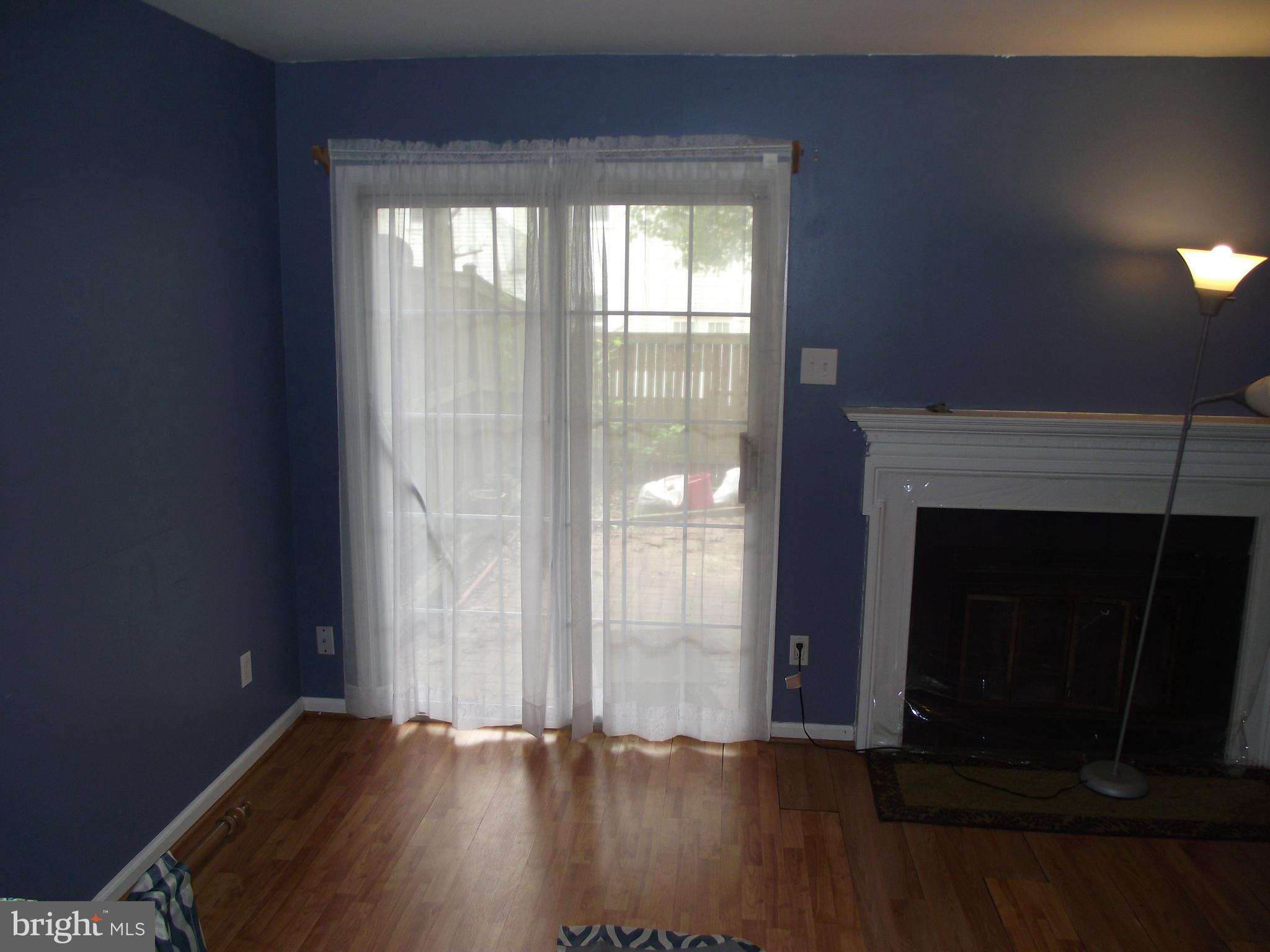 8502 Kernon Court, Unit BASEMENT APARTMENT Lorton, VA 22079 - Photo 6 of 10 an empty room with wooden floor fireplace and windows