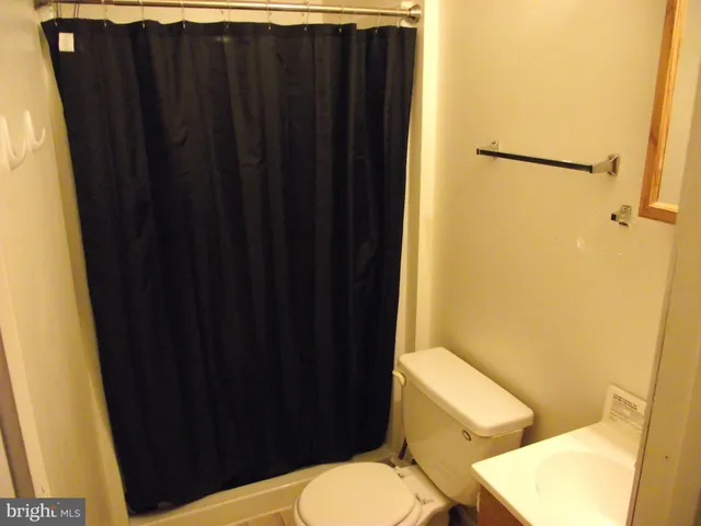 a bathroom with a black shower curtain
