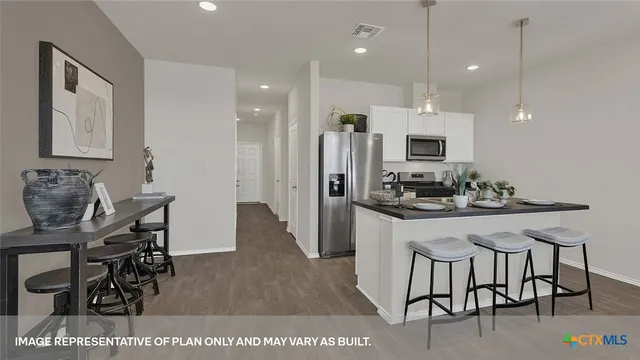 a kitchen with kitchen island a dining table chairs sink and cabinets