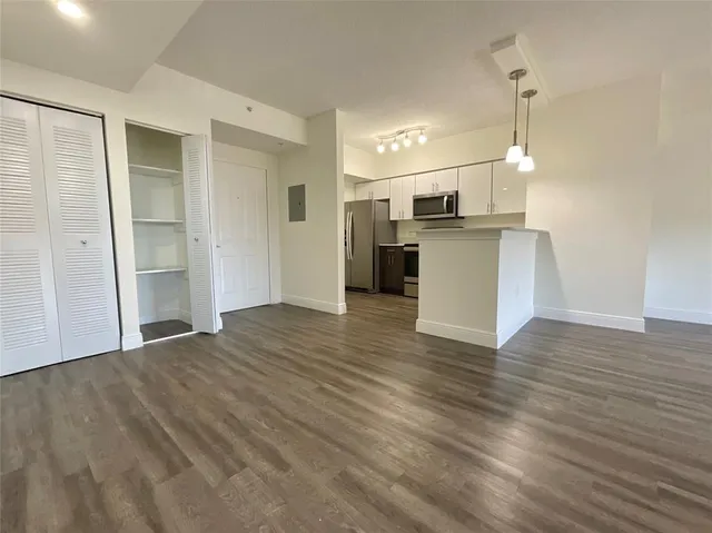 a view of a kitchen with a sink and dishwasher wooden floor