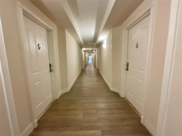a view of a hallway with wooden floor