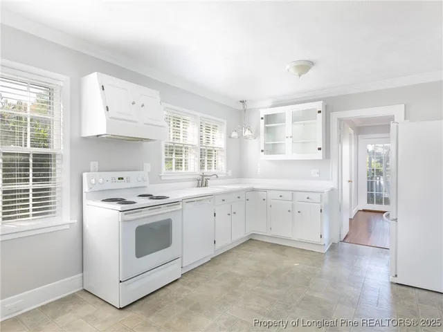 a kitchen with granite countertop white cabinets and white appliances