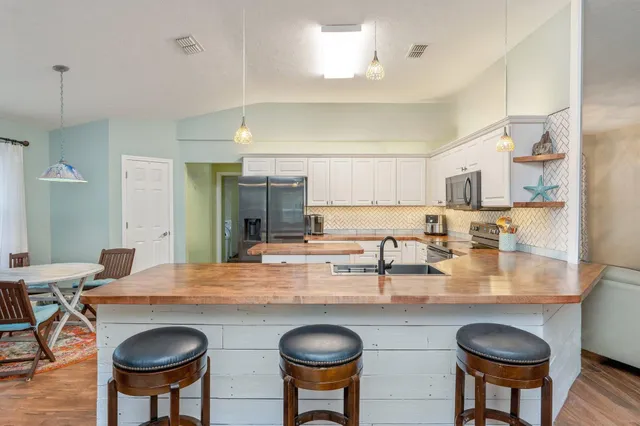 a kitchen with granite countertop a table and chairs in it