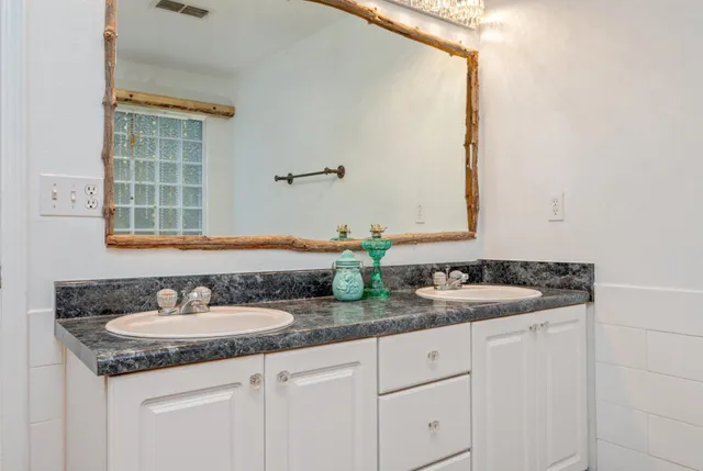 a bathroom with double sink and a mirror